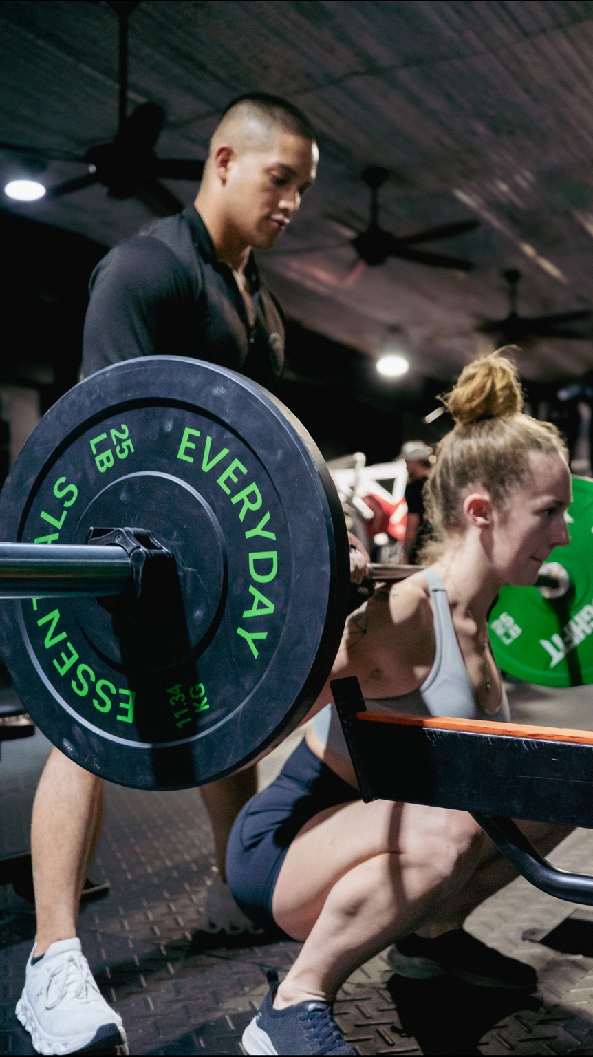 Coach assisting client with squat