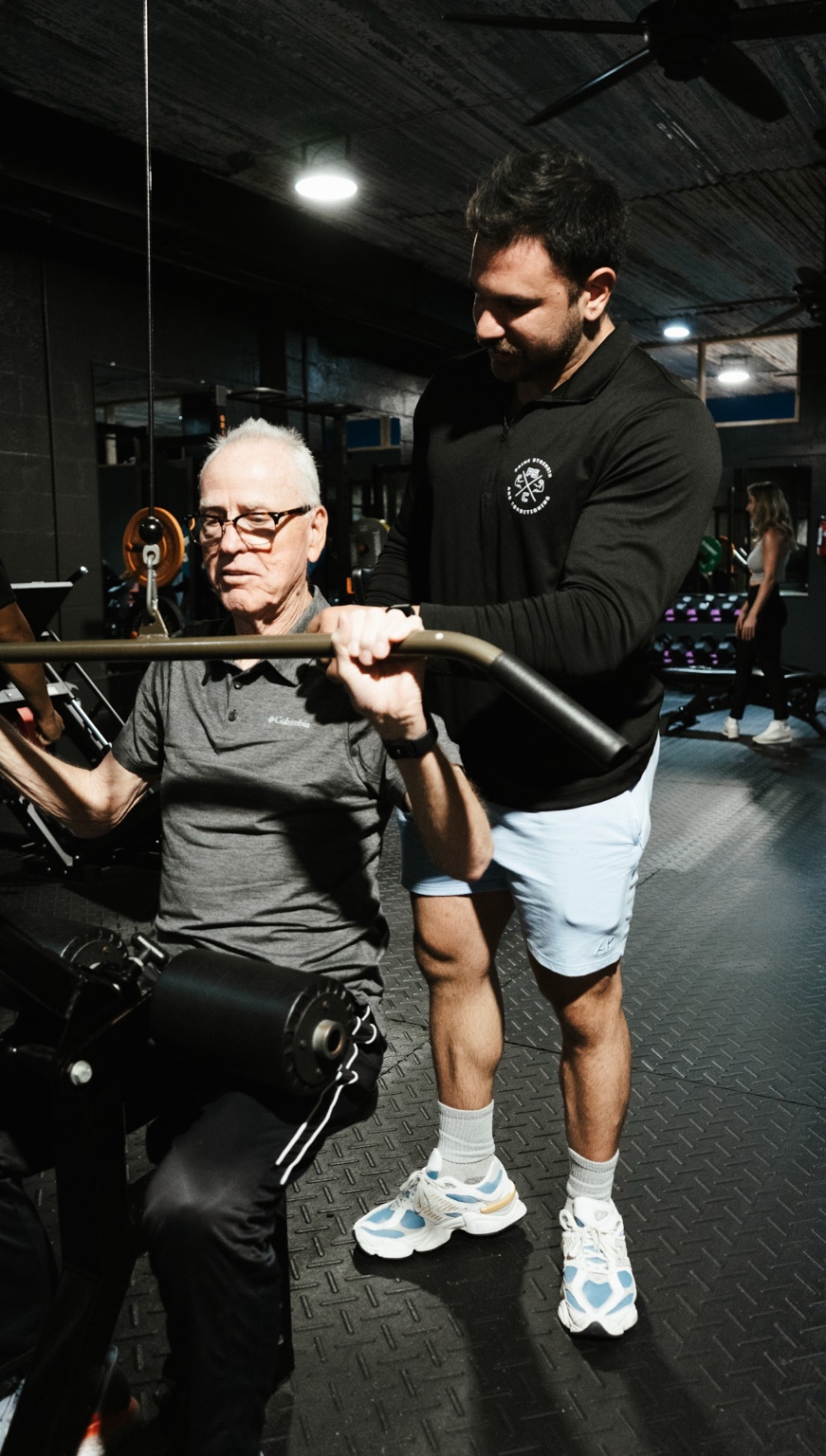 Trainer assisting an older adult client at Prime Strength and Conditioning